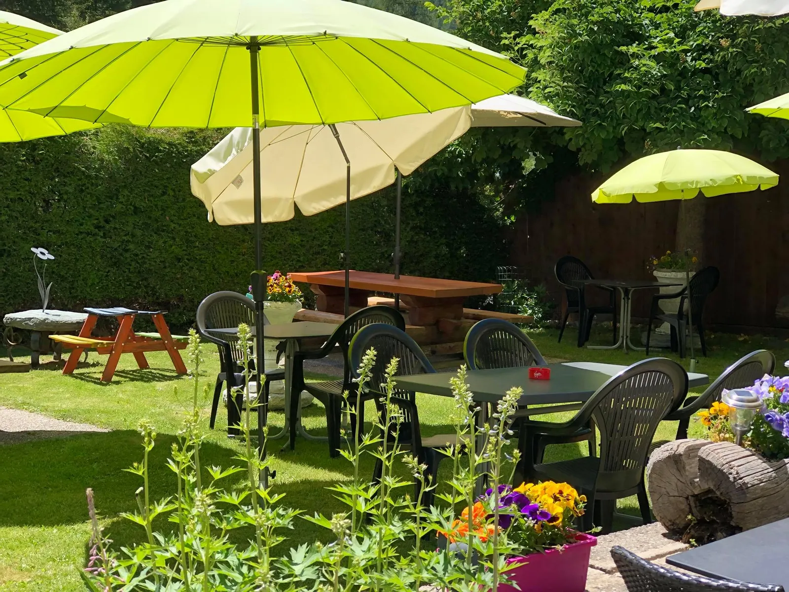 Le jardin ombragé, parasols et tables